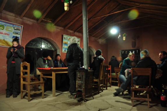 Pessoas se reúnem ao lado do fogareiro do nosso refúgio na Laguna Colorada, no sudoeste da Bolívia